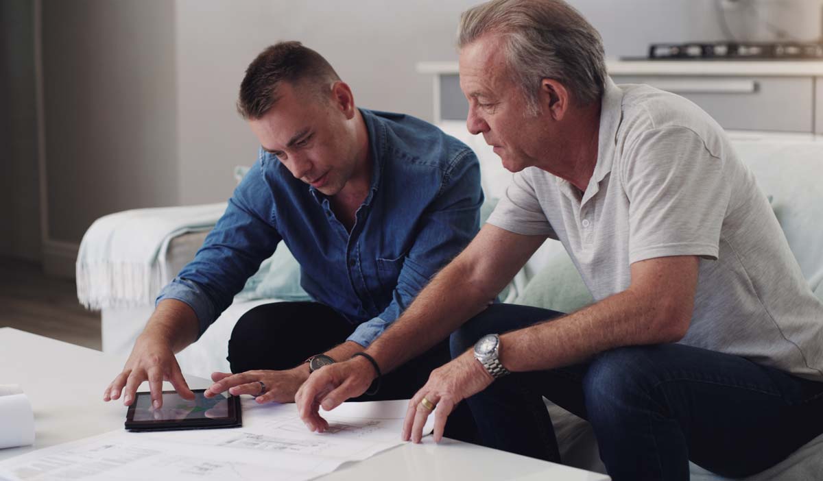 Designer And Client Reviewing Bespoke House Plans
