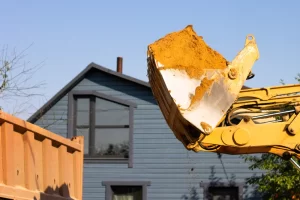 Excavator Demolishing A Small Residential House On A Suburban Street