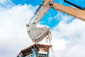 Worker In Safety Gear Performing Manual Demolition On A Residential Property